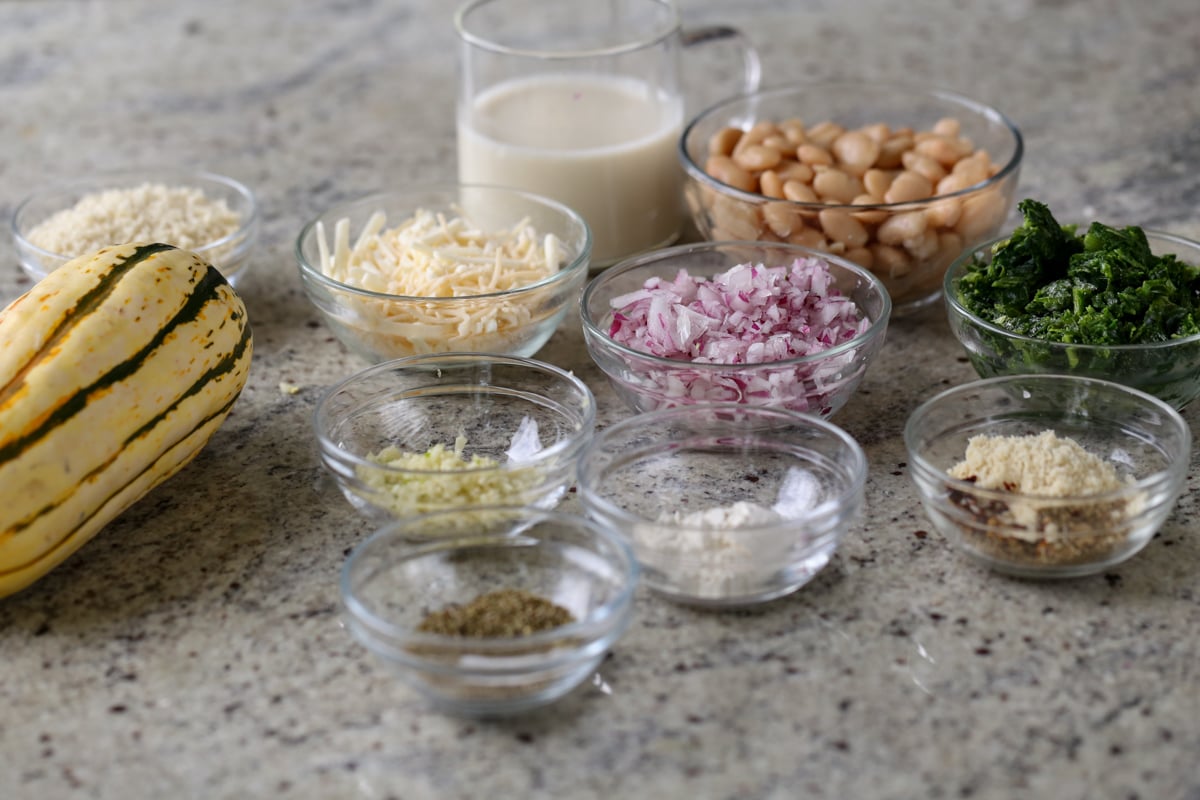 delicata squash, beans, vegan cheese, and other casserole ingredients on the kitchen counter