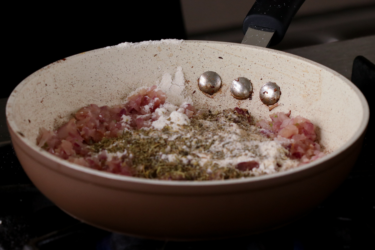 adding sauce ingredients to the onion and garlic in the pan