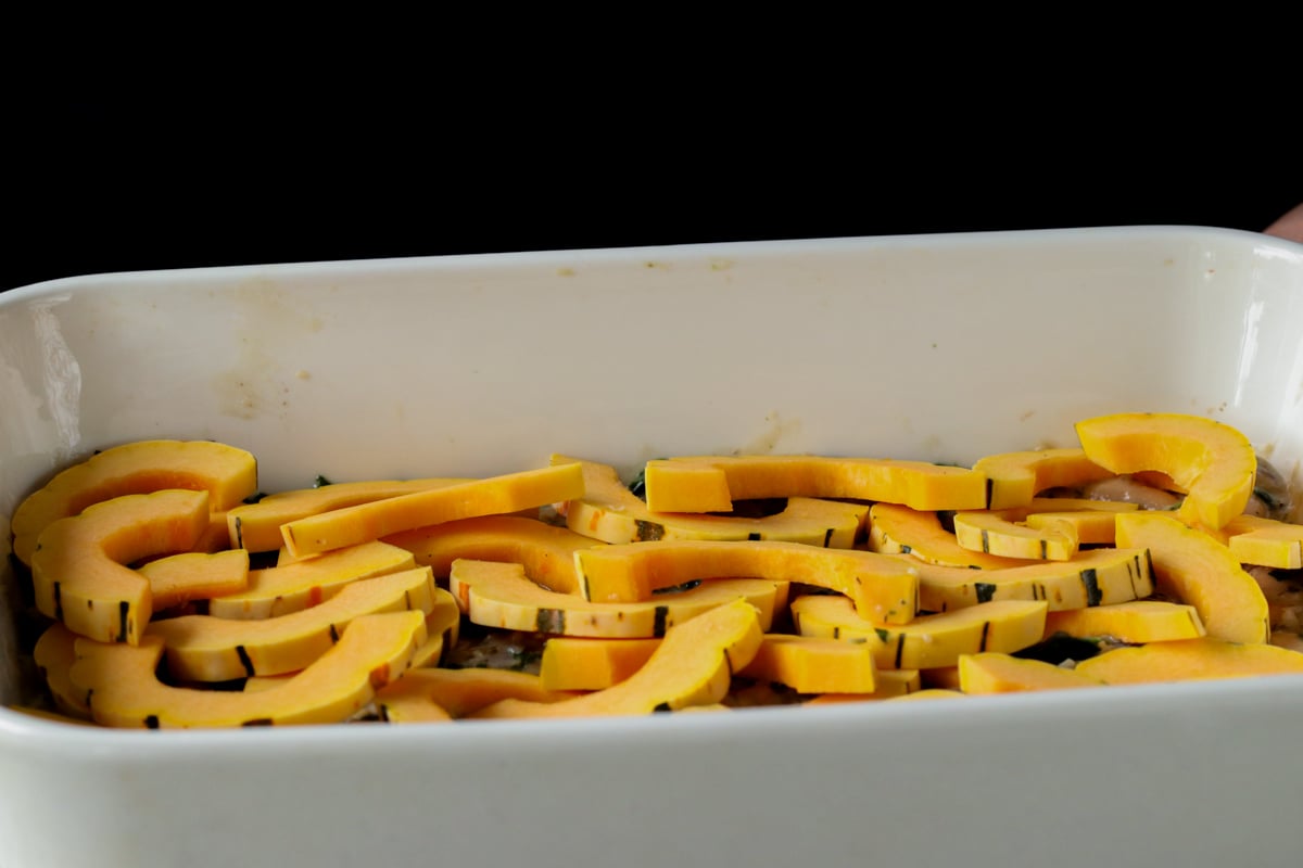 delicata squash layered over the beans mixture in the casserole dish