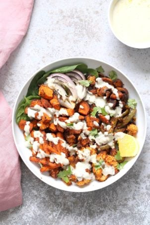Cajun Roasted Vegetable Bowl with Garlic Sauce. Mushrooms, Cauliflower, Sweet Potato, Peppers, Onions, tossed in cajun spice blend and roasted. Serve in a bowl with crunchy greens and creamy garlic sauce or make wraps or tacos. Vegan #Glutenfree #Soyfree #Recipe. Can be nut-free. | VeganRicha.com